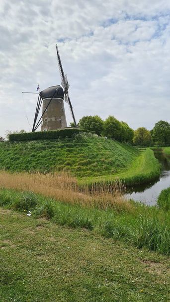 Reizen in Nederland. Uitzicht op traditionele romantische Nederlandse molens in het dorp Kinderdijk in Nederland voor zonsondergang. Horizontaal schot - Foto, afbeelding