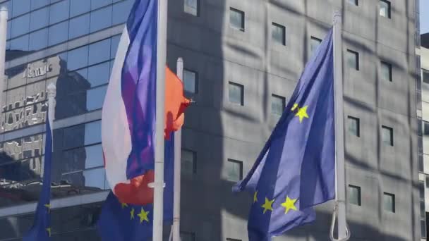 France and EU flag on flagpole excellent quality. French Republic and The European Union waving flag in wind background building glass skyscraper in Paris. High quality 4k footage - Materiał filmowy, wideo