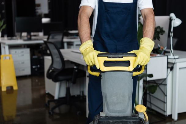 cropped view of man with floor scrubber machine working in blurred office - Photo, Image