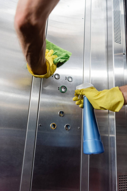 vista parziale di detergente in guanti di gomma lavaggio ascensore ufficio con straccio e detergente - Foto, immagini