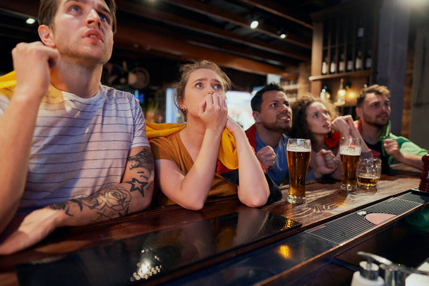 Grupa przyjaciół kibicujących meczowi piłki nożnej w pubie - Zdjęcie, obraz