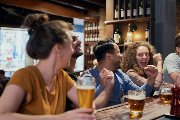 Group of friends spending time in bar together  - Foto, imagen
