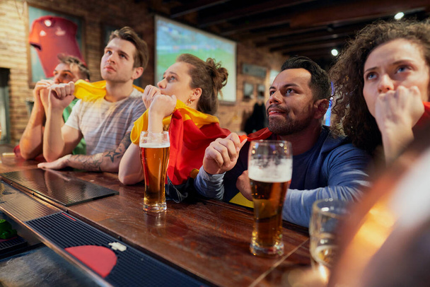 Bir grup arkadaş barda futbol maçı için tezahürat yapıyor. - Fotoğraf, Görsel
