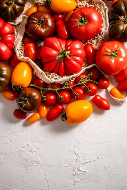 Tomatoes on the table. Tomatoes of different varieties. Circular composition with copy space. Flat lay, top view - Foto, Imagem