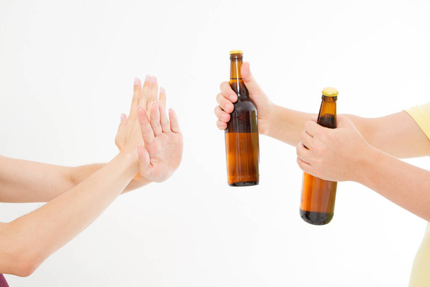 θηλυκό χέρι απορρίψει ένα μπουκάλι μπύρα που απομονώνονται σε λευκό φόντο.anti έννοια αλκοόλ. Αντιγραφή χώρου - Φωτογραφία, εικόνα