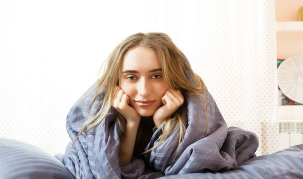 Schläfriges Mädchen am Morgen im Bett, junge schöne Frau, die in eine Decke gehüllt schläft. Schläfrige Schönheit Frau ruht sich auf Schlafzimmer aus. - Foto, Bild