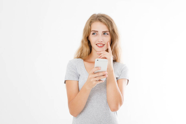 Νεαρή όμορφη γυναίκα σε t πουκάμισο χρησιμοποιώντας το smartphone της απομονώνονται σε λευκό φόντο. Σέξι ξανθιά κοπέλα συνομιλεί με φίλο ή ψωνίζει online. Αντιγραφή χώρου - Φωτογραφία, εικόνα