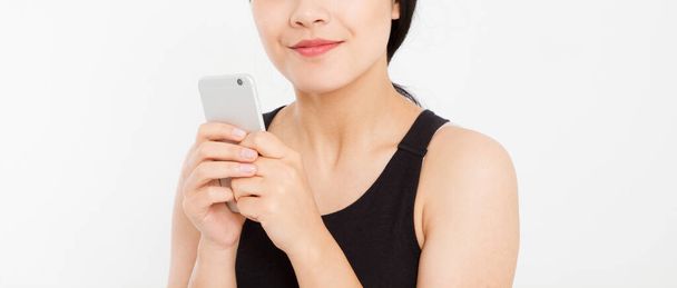 Una mujer mandando mensajes. Primer plano joven feliz hermosa asiática japonesa mujer. Chica mirando el teléfono móvil aislado sobre fondo blanco. Expresión facial positiva emoción humana. Copiar espacio. - Foto, imagen