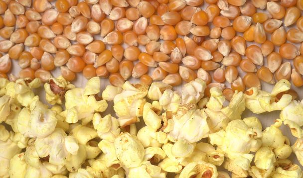 Raskas suola popcornia raaka maissi siemenet puinen pöytä. - Valokuva, kuva
