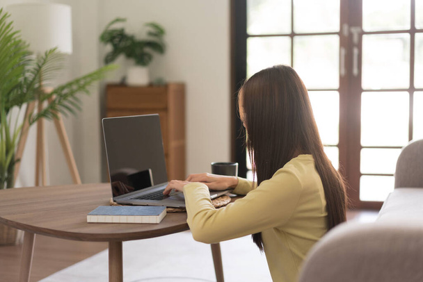 Концепція дозвілля, молода жінка друкує на ноутбуці, сидячи для розслаблення на підлозі
. - Фото, зображення