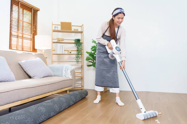 Housework concept, Housemaid use mop to mopping and cleaning dust on the floor in living room. - Fotografie, Obrázek