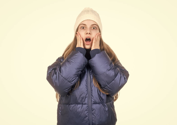 shocked teen girl in knitted hat and puffer padded jacket warm clothes isolated on white, down jacket. - Foto, Bild