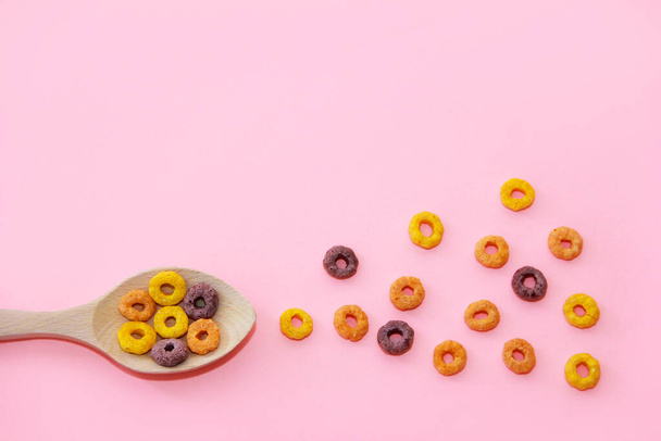 dry children's breakfast multicolored wheat rings in a wooden spoon - Фото, изображение