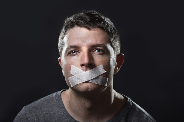attraktiver junger Mann mit abgedichtetem Mund, um ihn am Sprechen zu hindern - Foto, Bild