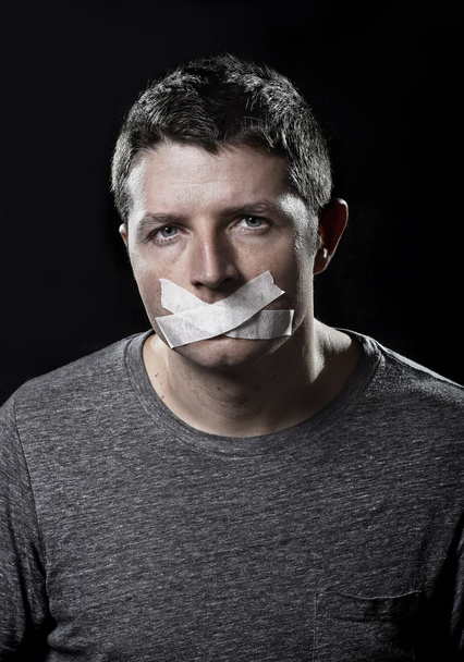 Viehättävä nuori mies suu suljettu ilmastointiteipillä estää häntä puhumasta
 - Valokuva, kuva