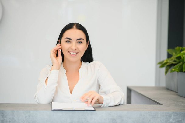 Brunette woman receptionist working in Reception of the beauty salon - Photo, Image