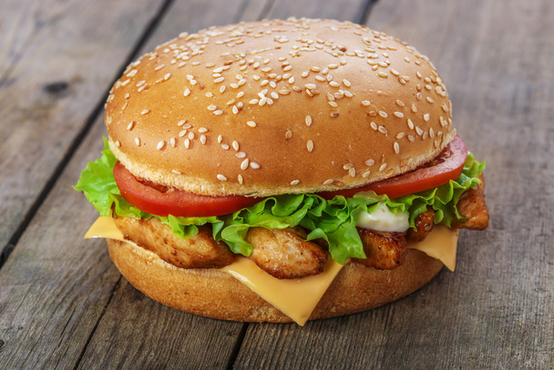 Hamburger with chicken and cheese on a wooden surface - Photo, Image
