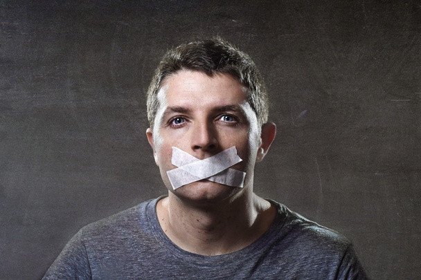 attraktiver junger Mann mit abgedichtetem Mund, um ihn am Sprechen zu hindern - Foto, Bild