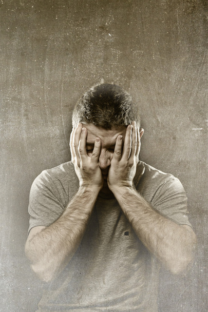 Мужчина страдает депрессией, головной болью, мигренью и болью, покрывающей лицо руками
 - Фото, изображение
