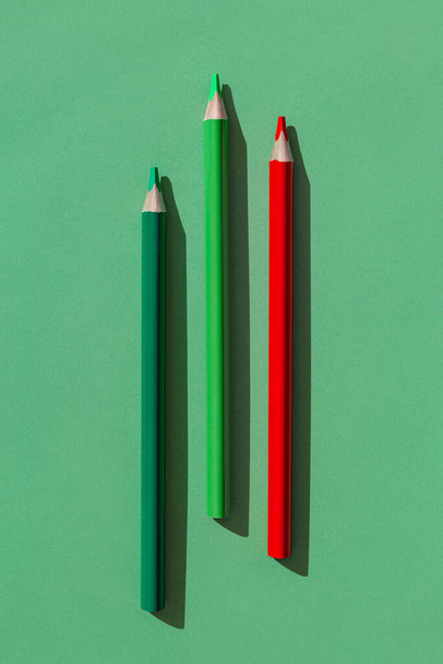 Colorful wooden pencils on green background. Minimal style composition. Top view. Flat lay. Back to school concept - Foto, Imagen
