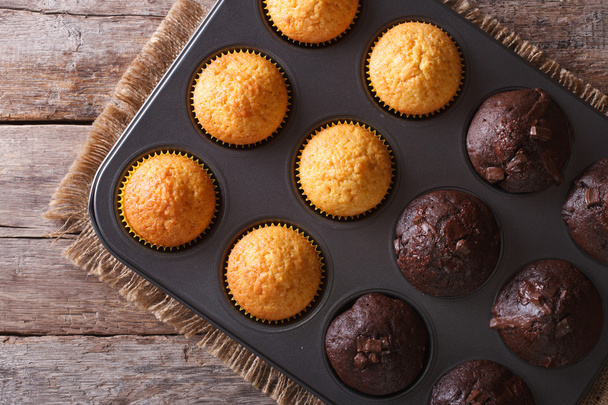 chocolade en vanilla muffins in bakken schotel bovenaanzicht - Foto, afbeelding