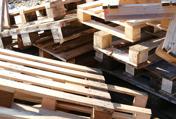 pilha de paletes de madeira empilhadas em um aterro
 - Foto, Imagem