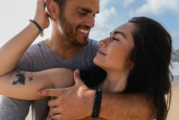 portrait of cheerful and tattooed woman hugging with bearded boyfriend against sky  - Foto, imagen