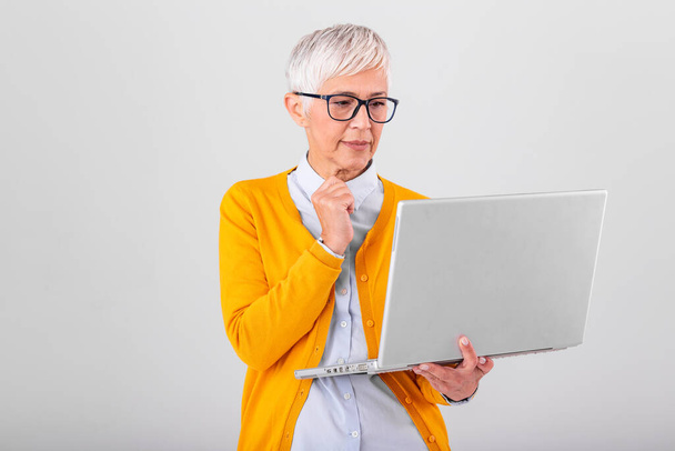 Przemyślane mylić biznes Dorosła kobieta zainteresowanych myślenia o problemie online, patrząc na laptopa, sfrustrowany martwi się starszy średniej wieku kobiece czytanie e-mail bad news, cierpiących na utratę pamięci - Zdjęcie, obraz