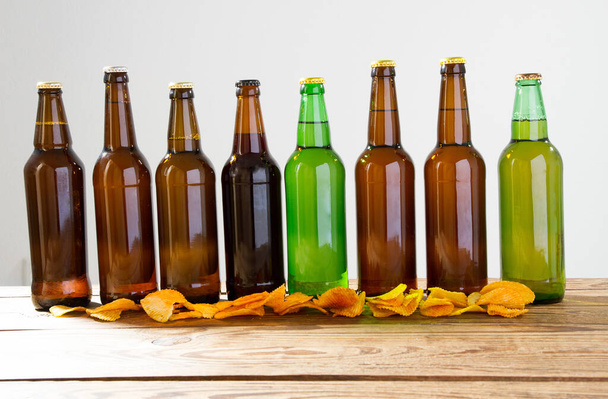 Beer bottles on a wooden table . Potato chips. Top view. Selective focus. Mock up. Copy space.Template. Blank. - Photo, Image