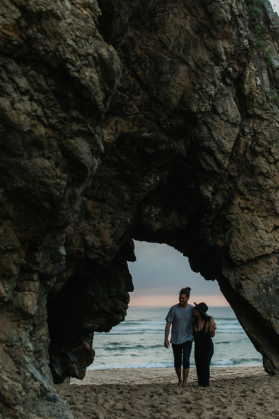 Sakallı adam ve kadın gün batımında kumlu sahilde yürüyorlar. - Fotoğraf, Görsel