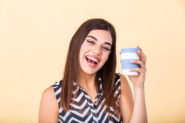 Coffee lover concept. Closeup photo portrait of delightful cheerful positive with toothy beaming smile person holding cup of warm latte in hands cuddling to herself isolated bright color background - Foto, immagini