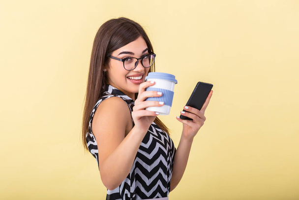 Coffee lover concept. Closeup photo portrait of delightful cheerful positive with toothy beaming smile person holding cup of warm latte in hands cuddling to herself isolated bright color background - Fotó, kép