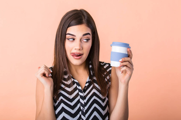 Coffee lover concept. Closeup photo portrait of delightful cheerful positive with toothy beaming smile person holding cup of warm latte in hands and licking her lip isolated bright color background - Foto, immagini