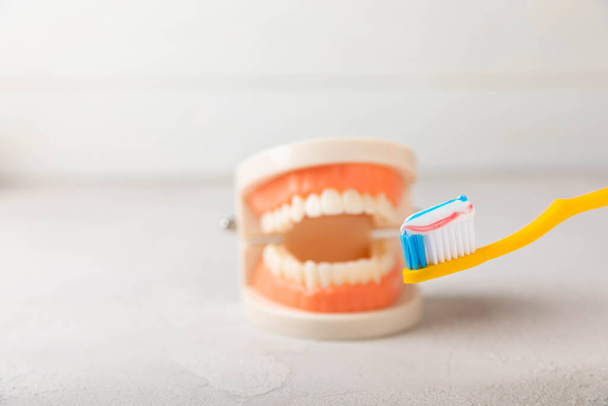 Dentures with a toothbrush on a white background. Upper and lower jaws with false teeth. Dentures or false teeth, close-up. copy space.MOCKUP - Photo, image