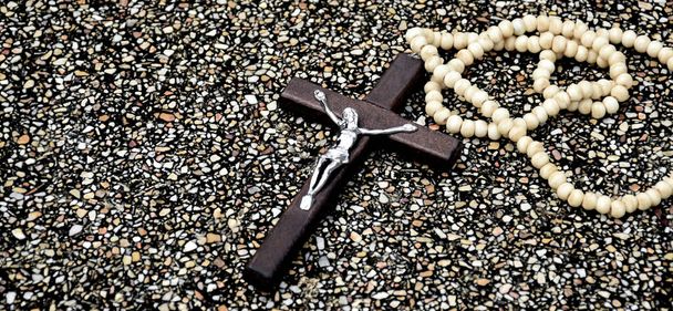 Wooden cross bead necklace on marble stone, soft and selective focus. - 写真・画像