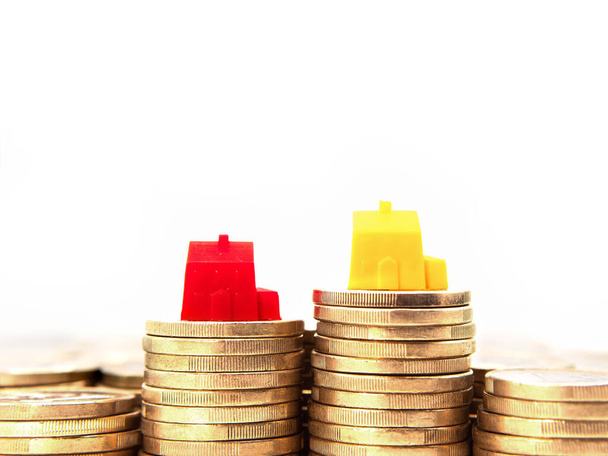 Two toy houses on coins. Concept of house price and mortgage. Selective focus. - Foto, Imagen
