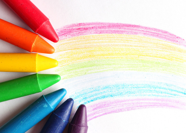 Crayons pastel à l'huile couchés sur un papier peint arc-en-ciel
 - Photo, image