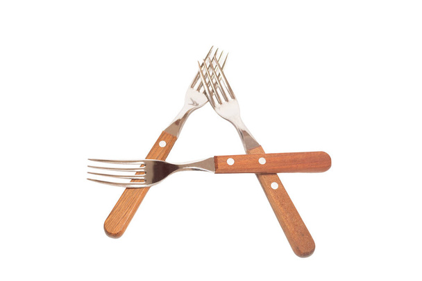 3 forks with wooden handles making the letter A on a white background - Foto, imagen