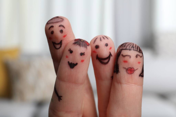 Four fingers with drawings of happy faces on blurred background - Valokuva, kuva