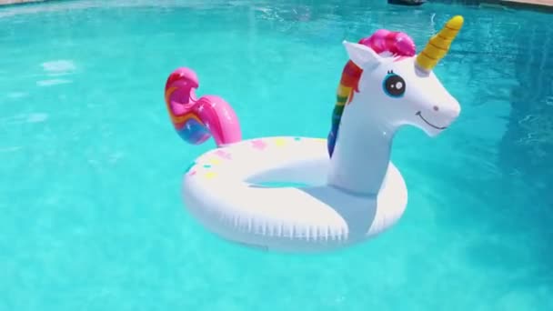 a white inflatable circle in the shape of a unicorn floats in the pool - Video