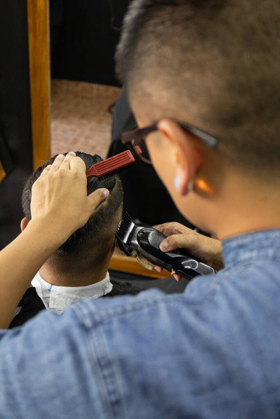 парикмахер с помощью бритвы выполняя стрижку, работа в парикмахерской, личный уход, красота и стиль, профессиональная профессия - Фото, изображение