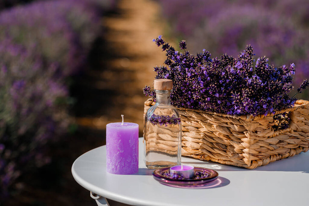 Basket with beautiful lavender in the field in Provance with Lavander water and candles. Harvesting season - Foto, Imagem