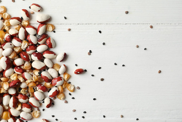 Mixed vegetable seeds on white wooden background, flat lay - Valokuva, kuva