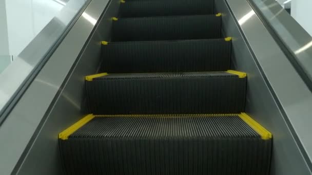 Using Escalator. Point of view or POV Video footage. Close up shot of empty moving staircase running up and down. Modern escalator stairs move indoors going up and down. Escalator with glass sides. - Felvétel, videó
