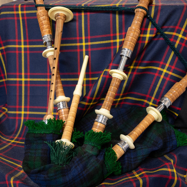 Symbols of Scotland - wollen tartan textile and handmade musical instrument bagpipes, close up - Foto, Imagen