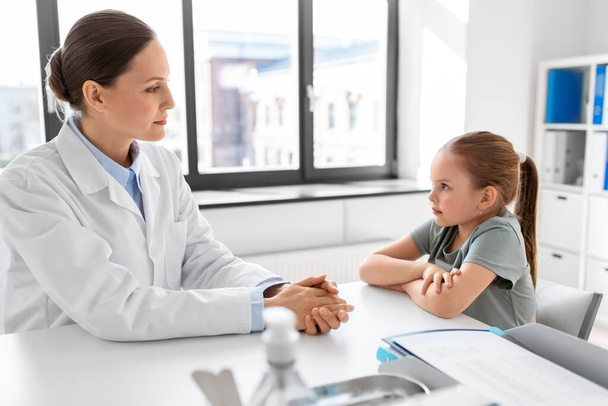 medicine, healthcare and pediatry concept - female doctor or pediatrician talking to little girl patient on medical exam at clinic - Foto, Imagen