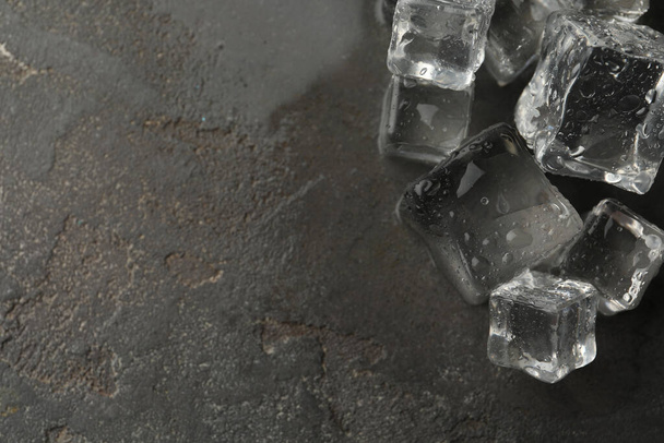 Crystal clear ice cubes with water drops on grey table, flat lay. Space for text - Fotó, kép