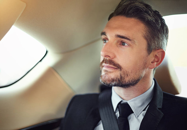 Hes got business on the mind. a businessman in the backseat of a car - Foto, Bild