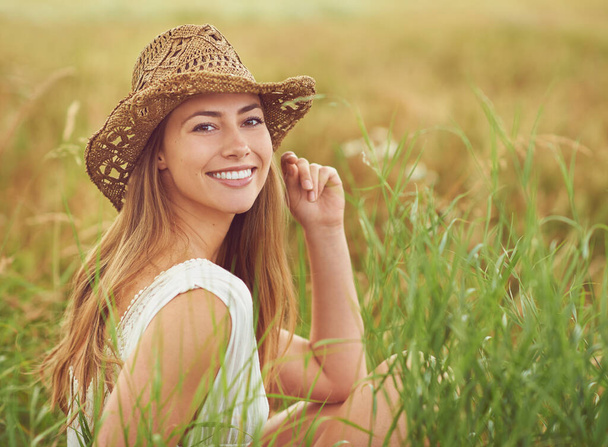 Breathe the fresh air of the countryside. a young woman sitting in a field in the countryside - 写真・画像