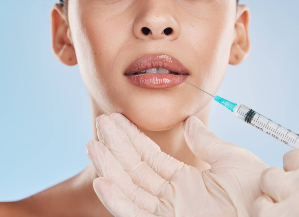 Plastic surgery, collagen and lip filler for facial beauty aesthetic and medical cosmetic surgery. Hands of face augmentation surgeon or doctor working on patient or client lips with injection needle. - Foto, Imagen